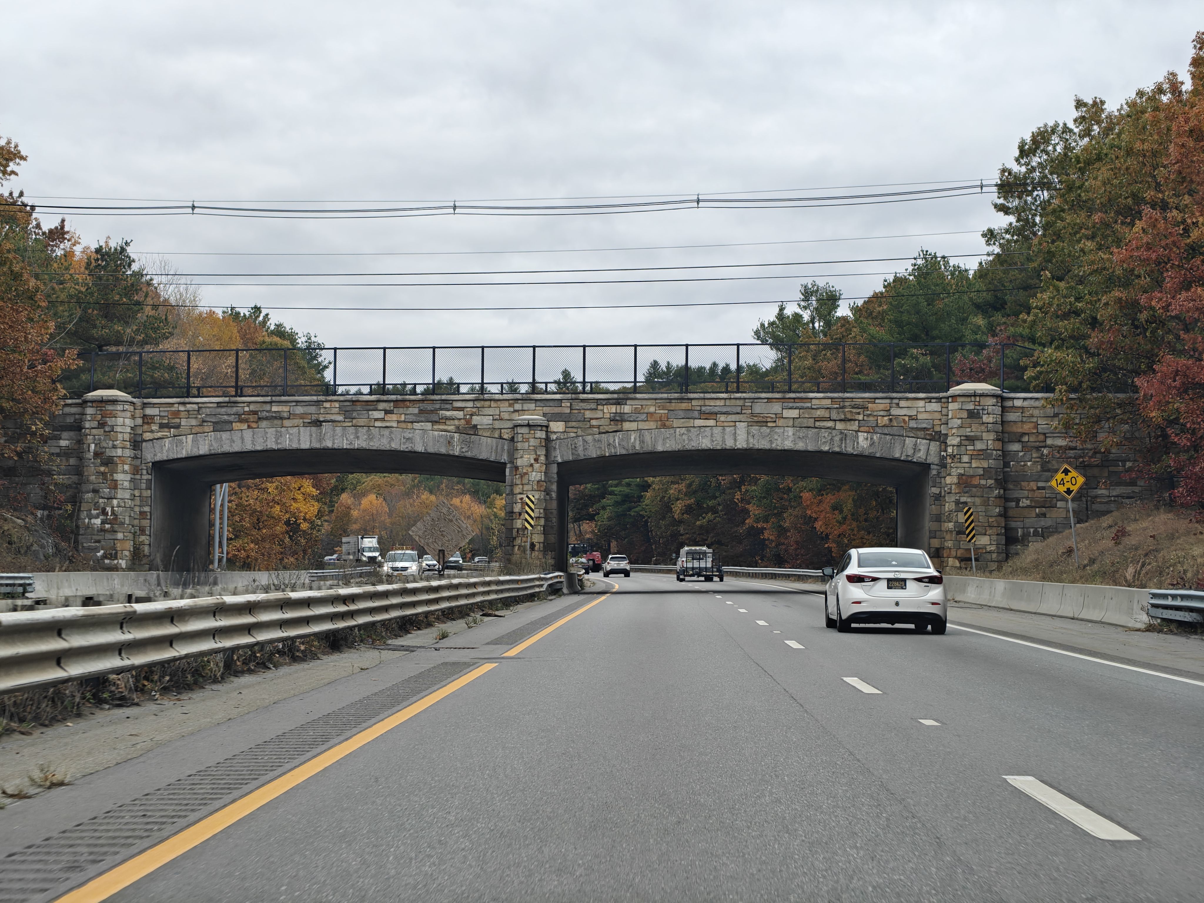 a stone clad arch bridge over a road
